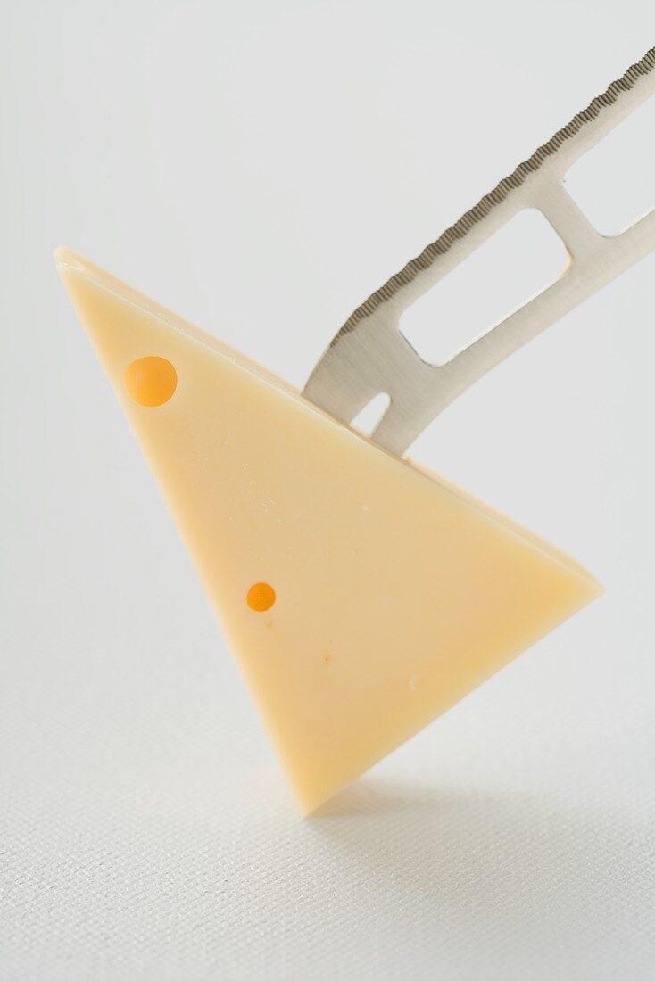 Piece of Emmental cheese on the point of a knife