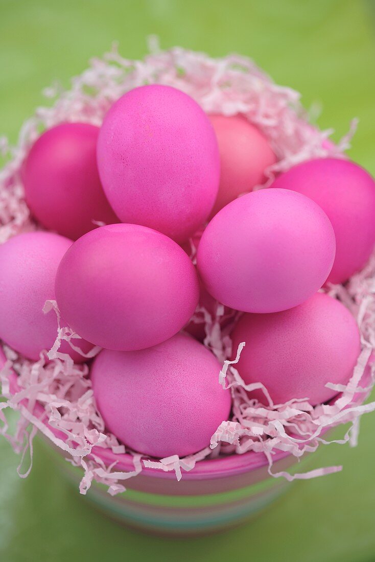 Pink Easter eggs on Easter grass in bowl