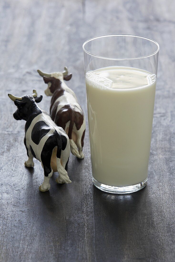 Glas Milch und zwei Kuhfiguren