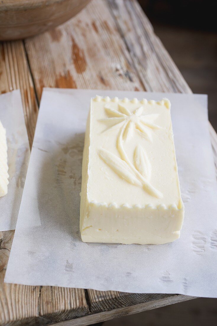 Butter with a flower design (from a wooden mould) on paper