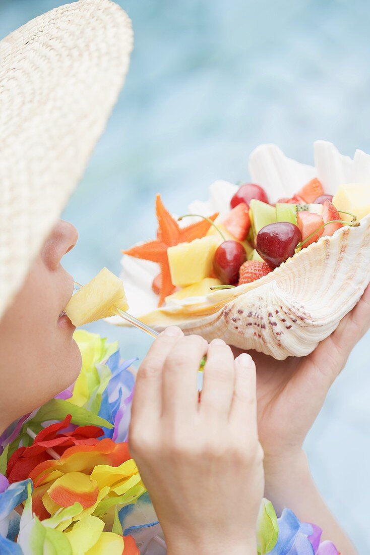 Woman eating fresh fruit out of shell