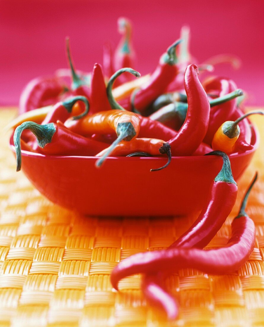 Red and orange chillies in a red bowl