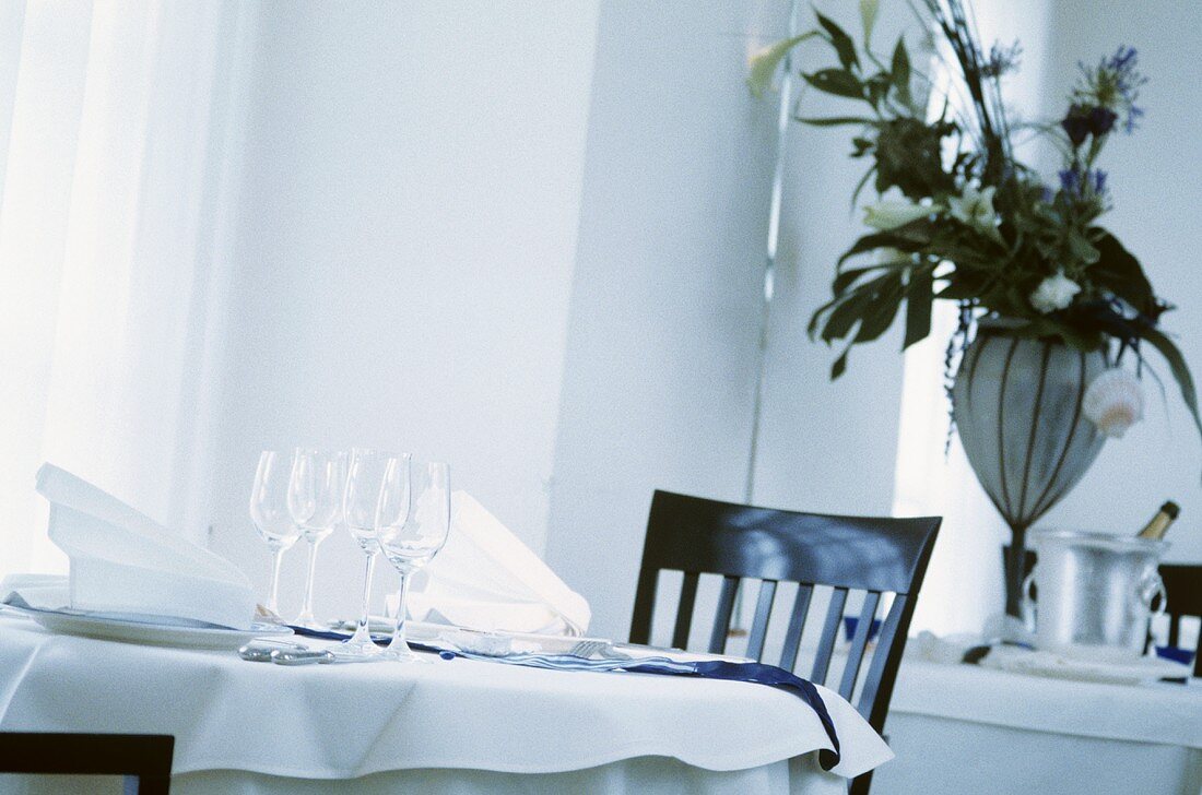 Weiß gedeckter Tisch mit Weingläsern