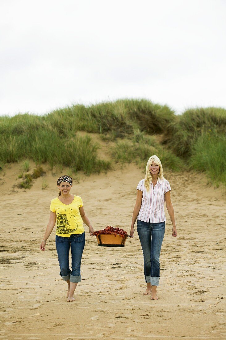 Zwei Frauen auf dem Weg zum Picknick am Strand