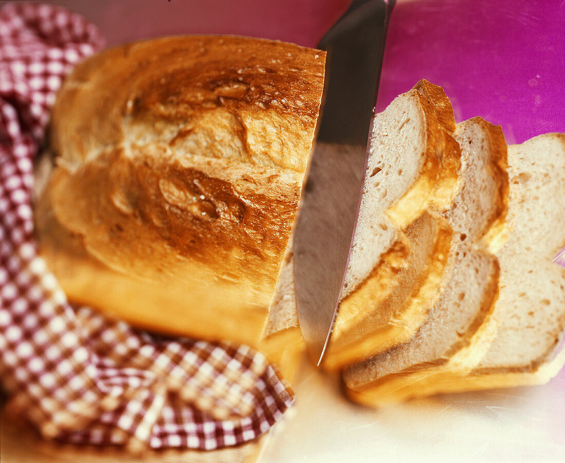 A loaf of white bread with knife