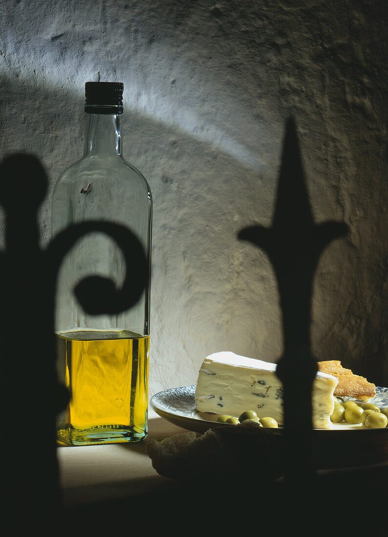 Still life with cheese, bread, olives and oil