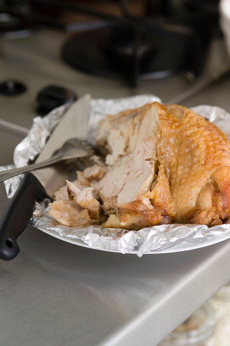 A piece of roast turkey on aluminium foil