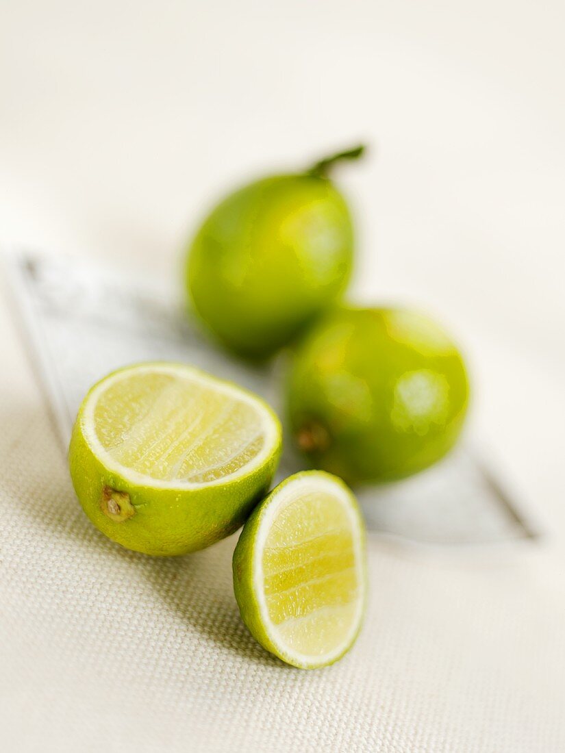 Two whole limes and one cut open