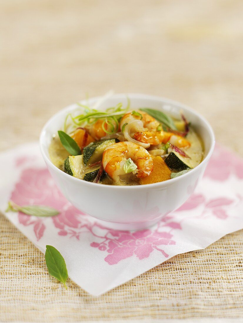 Shrimp curry with vegetables and basil in a small bowl