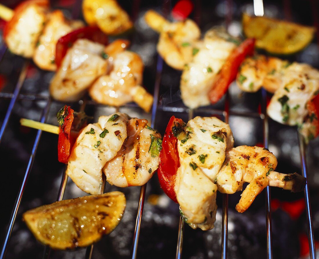 Several seafood kebabs on a barbecue