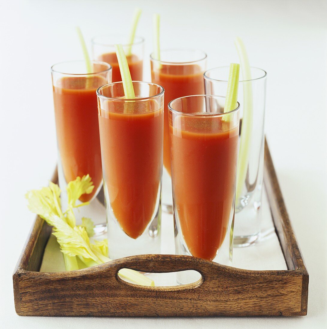 Several glasses of tomato juice on a tray