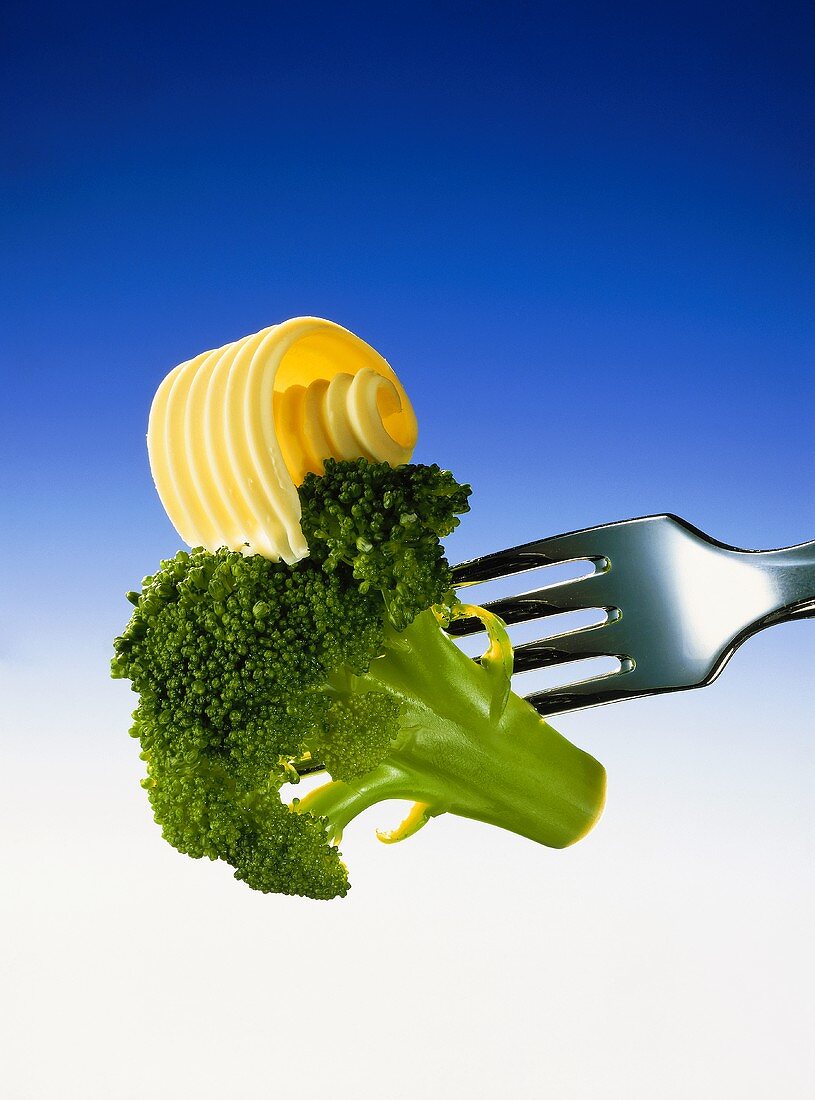 Ein Broccoliröschen mit Butterlocke gehalten von einer Gabel