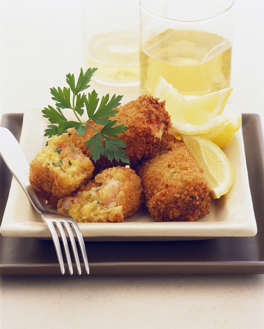 Breaded shrimp and crab cakes with lemon wedges