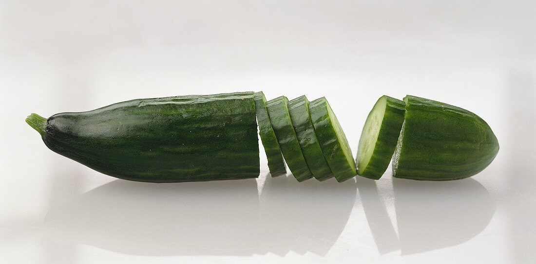 A cucumber with slices cut in middle
