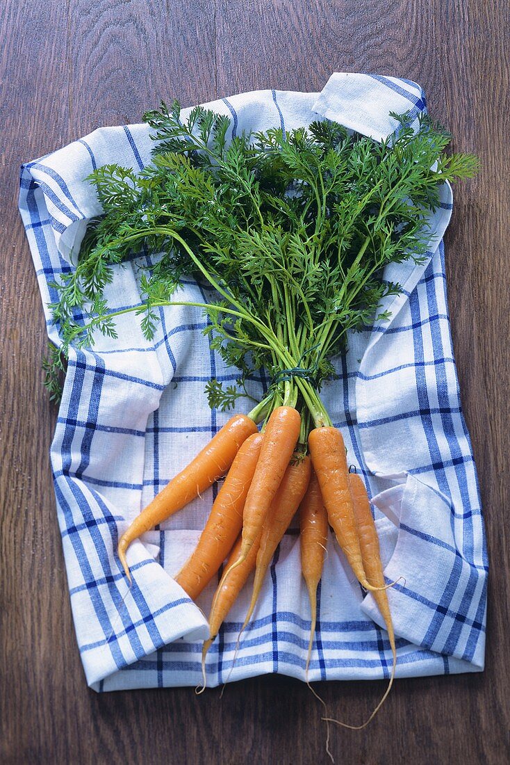 A bunch of carrots on a tea towel