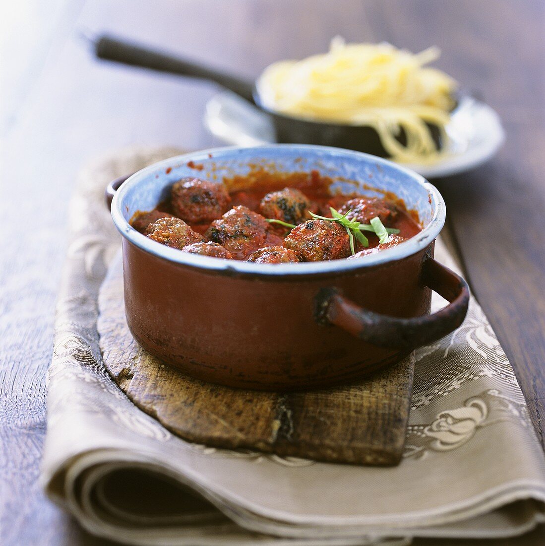 Pan of meatballs in tomato sauce with spaghetti