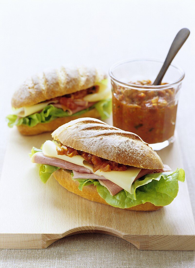 Two ham and cheese sandwiches with tomato relish