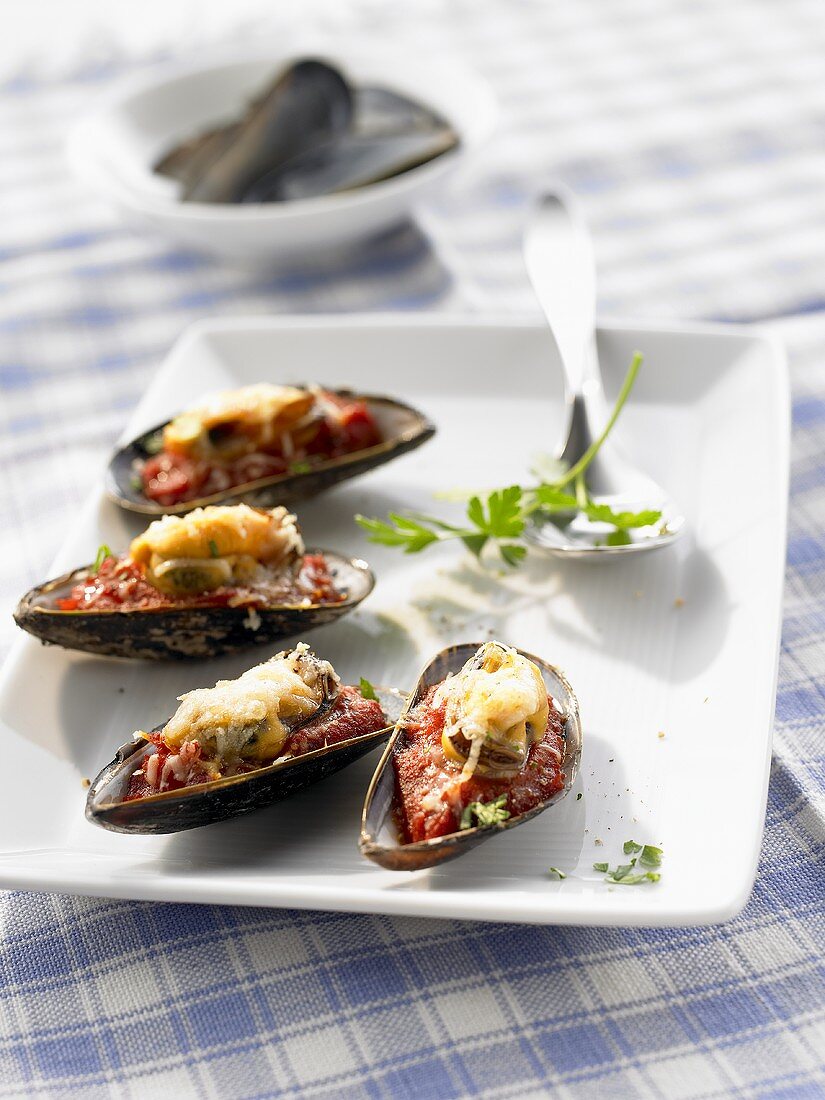 Mussels on tomato sauce with toasted cheese topping