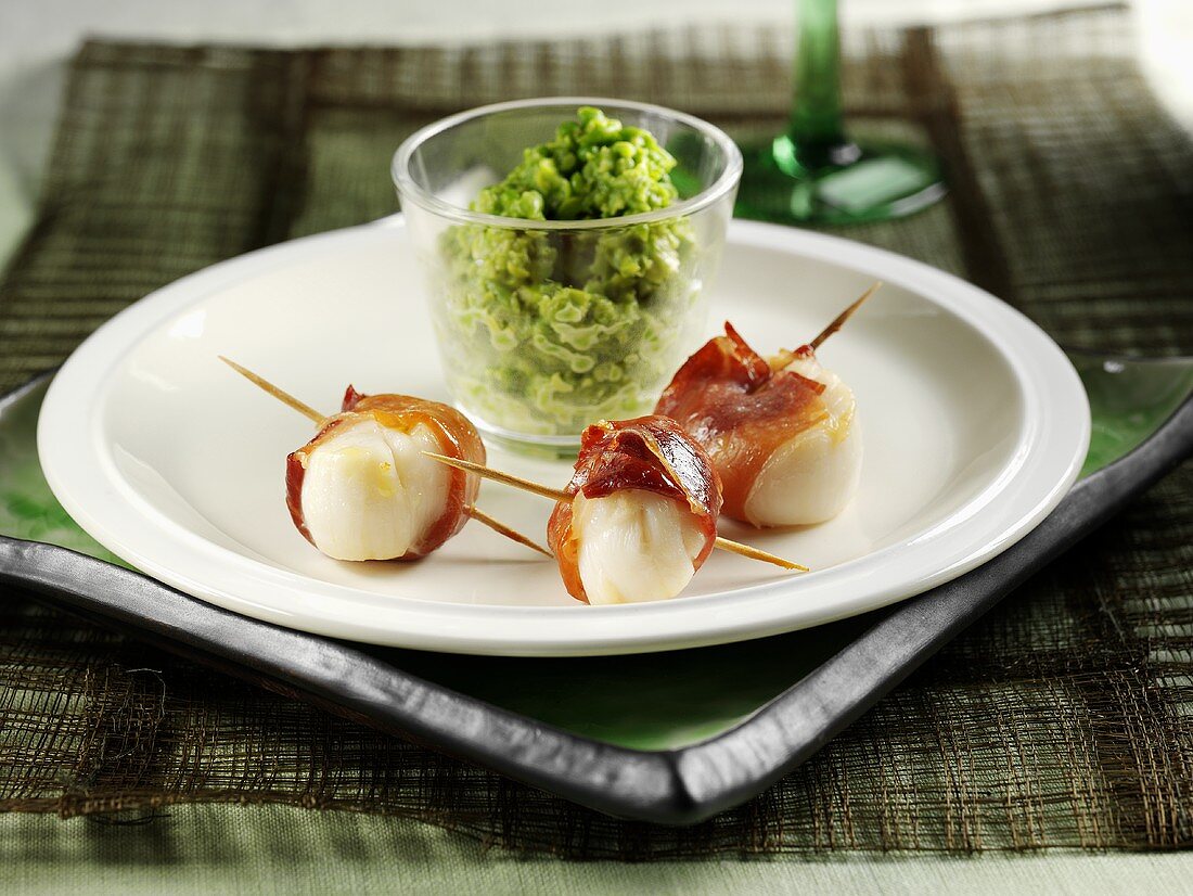 Three scallops wrapped in ham with herb butter