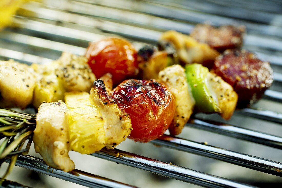 Two vegetable kebabs lying on a barbecue