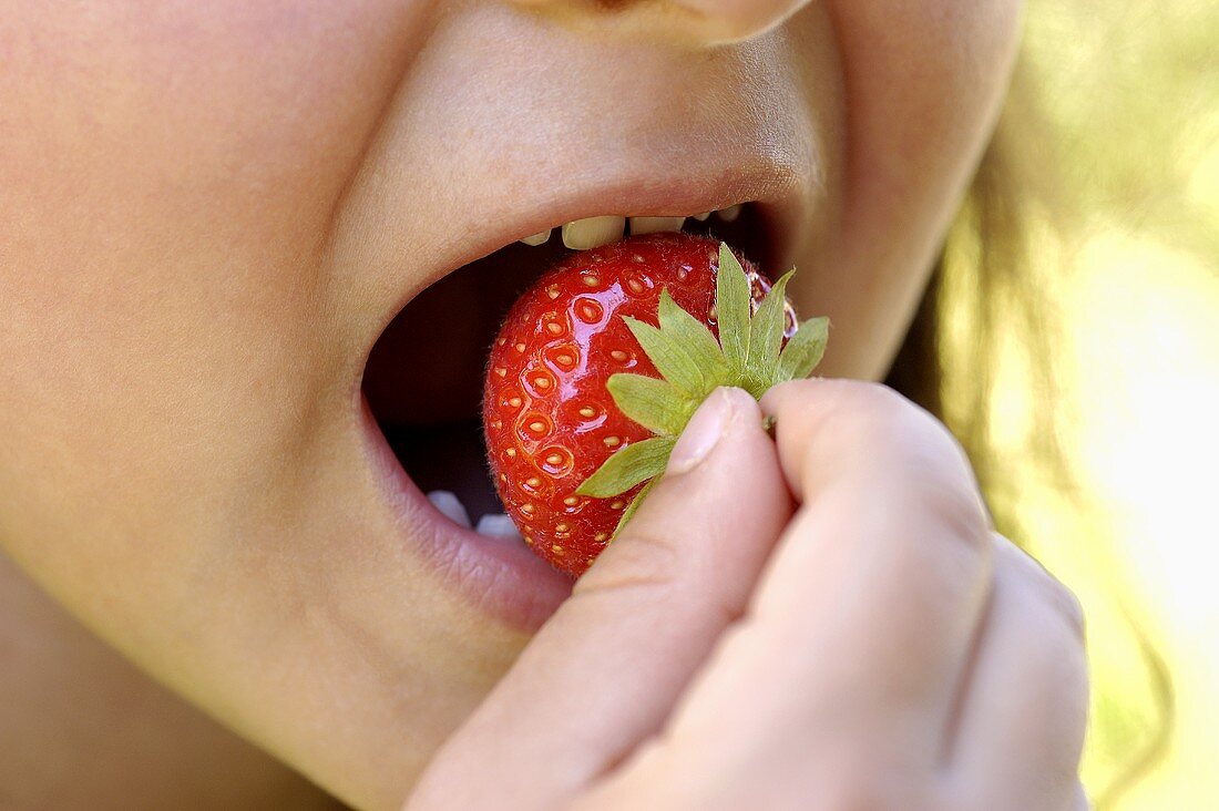 Girl with strawberry in her mouth