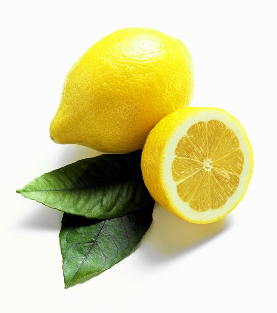 Ganze und halbe Zitrone mit Blättern