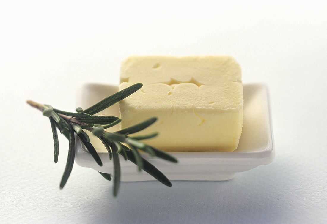 Fresh Butter in a White Butter Dish with Rosemary