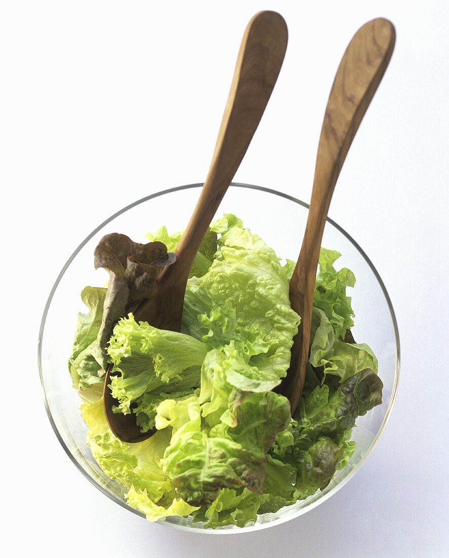 Gemischter Blattsalat in Glasschüssel mit Salatbesteck