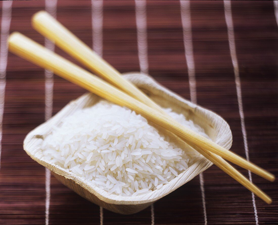 A Dish of Uncooked White Rice with Chopsticks