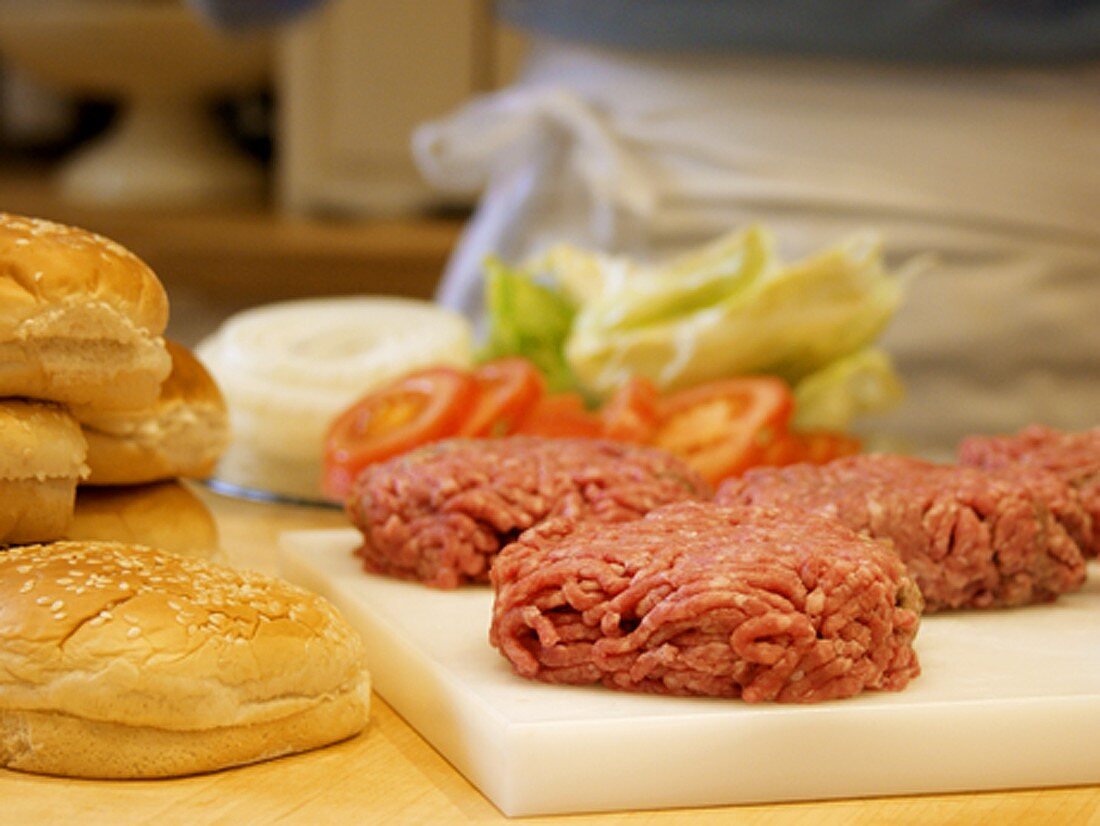 Hamburger Patties on a Cutting Board with Buns