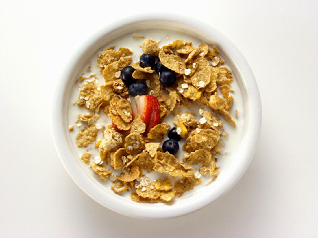 Cornflakes mit Milch, frischen Erdbeeren und Heidelbeeren