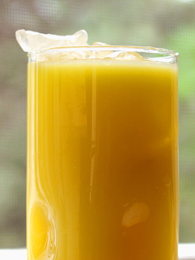 Orangensaft mit Eiswürfeln im grossen Glas