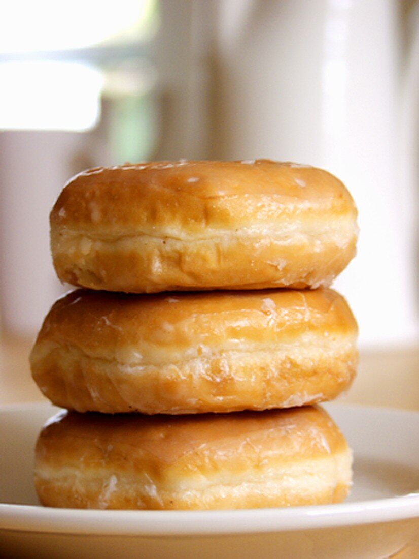 Drei Doughnuts mit Zuckerglasur, gestapelt