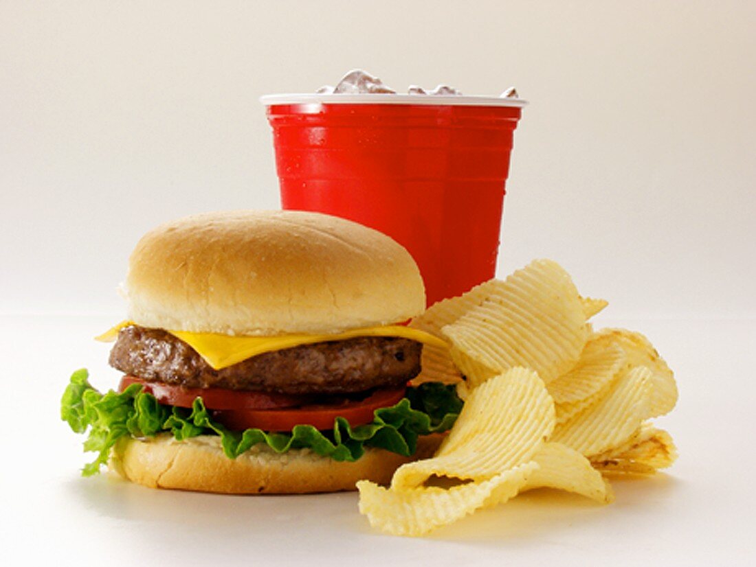 A Cheeseburger with Potato Chips and Soda
