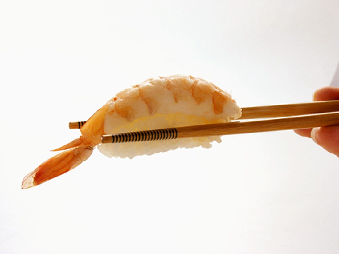 Stäbchen halten Nigiri-Sushi mit Garnele
