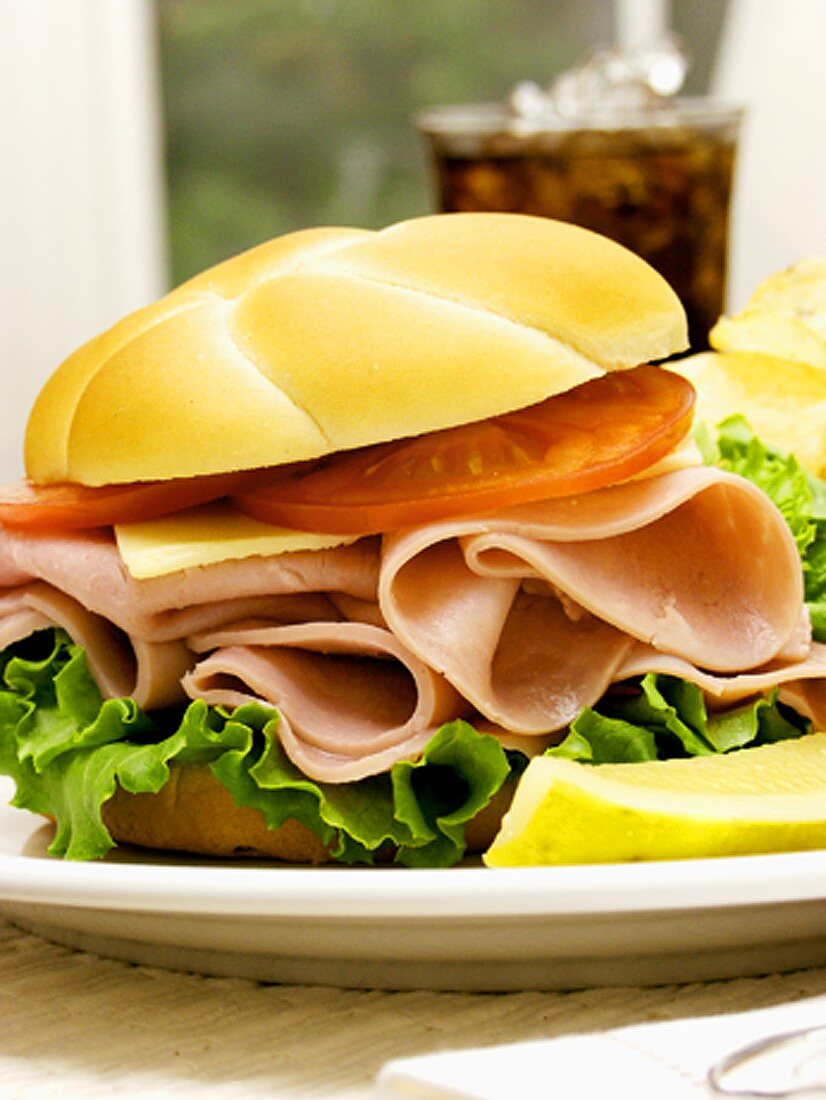 Schinkenbrötchen mit Käse, Tomaten und Chips; Cola