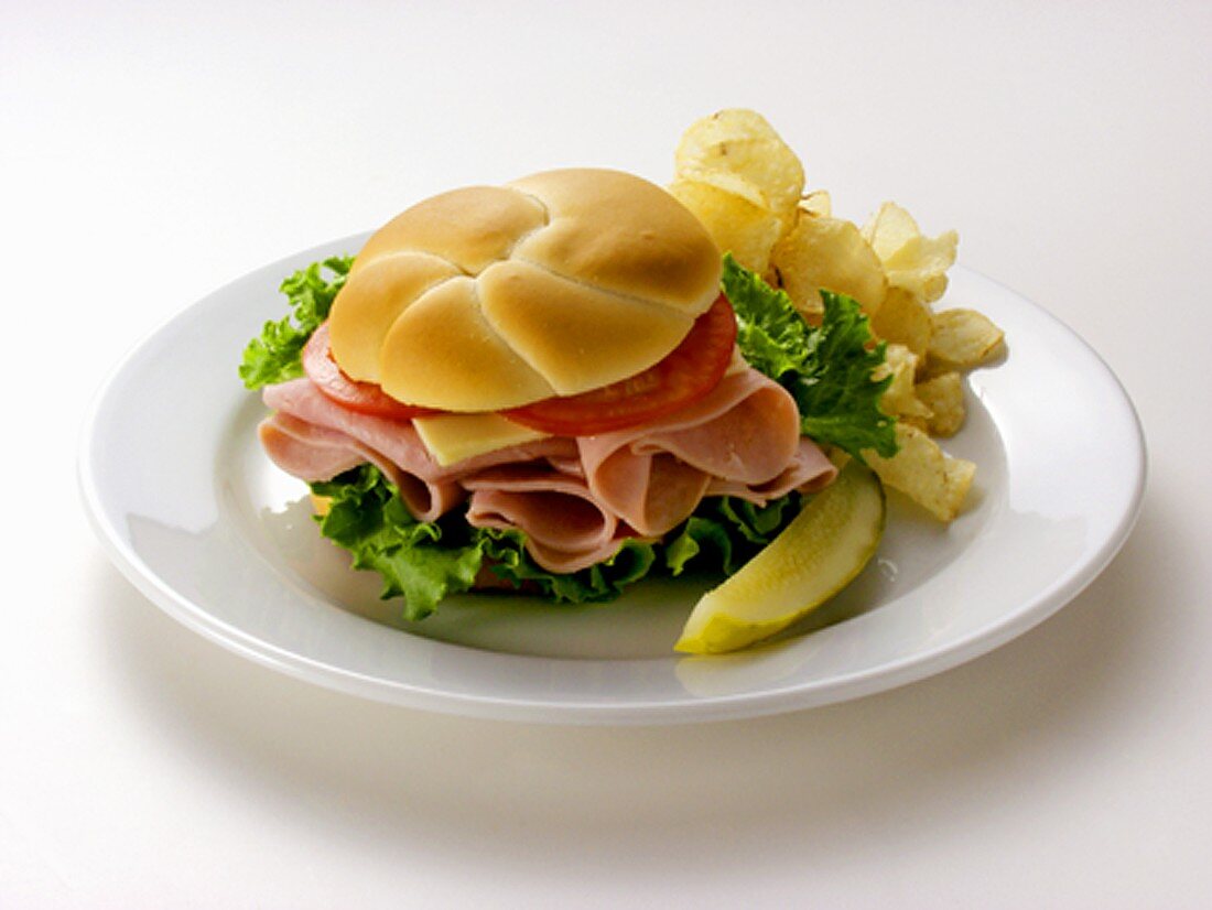 A Ham Sandwich with Chips and a Pickle