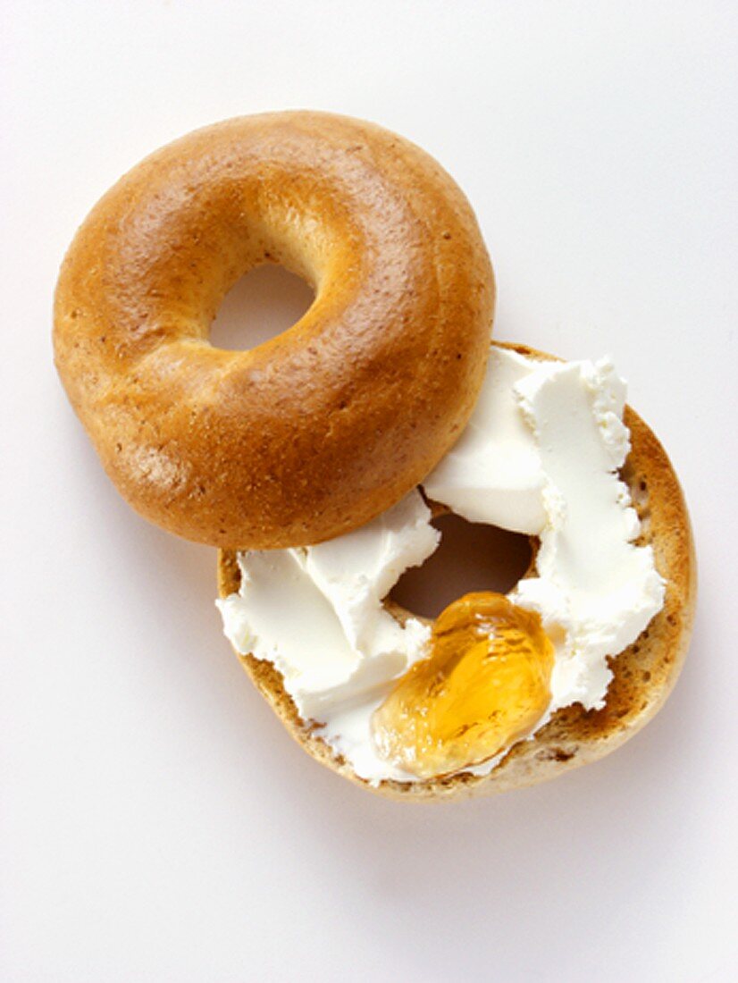 A Toasted Bagel with Cream Cheese and Apple Jelly