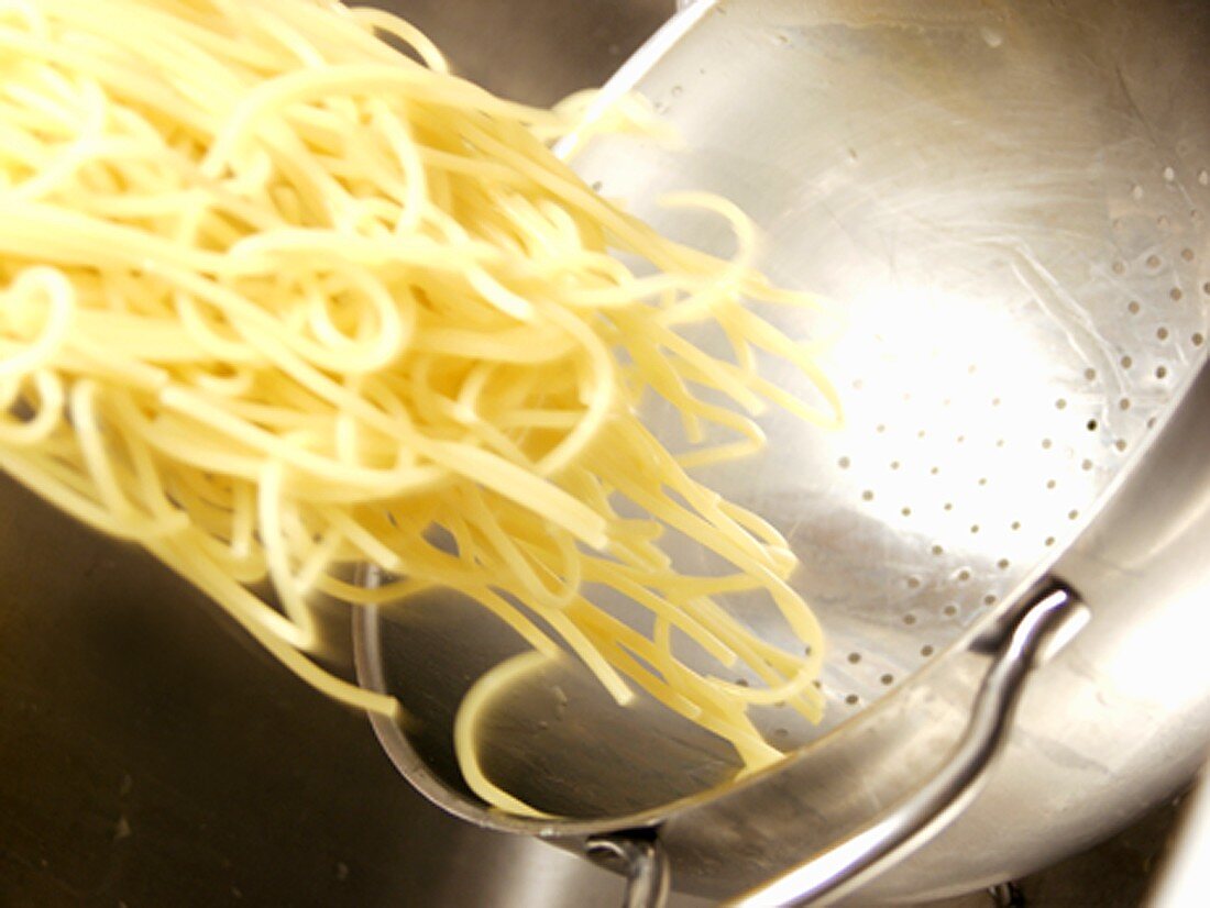 Cooked Pasta being Taken out of Colander