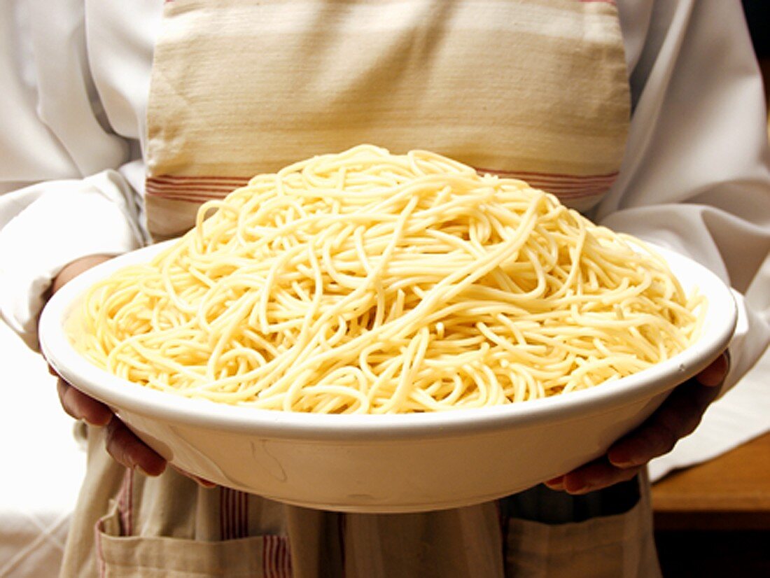 A Bowl of Spaghetti Being Held