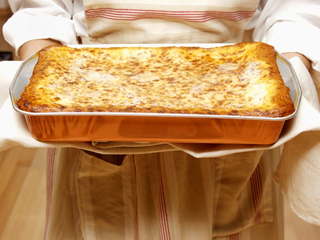 Woman Holding a Pan of Lasagna