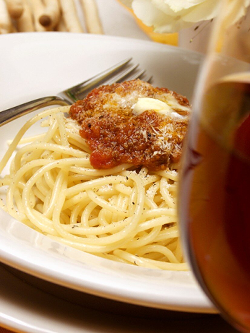 Spaghetti Bolognese mit Butter und Parmesan; Glas Rotwein