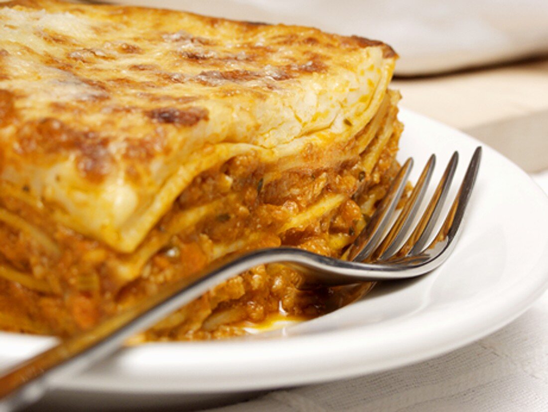 A Piece of Lasagna on Plate with Fork