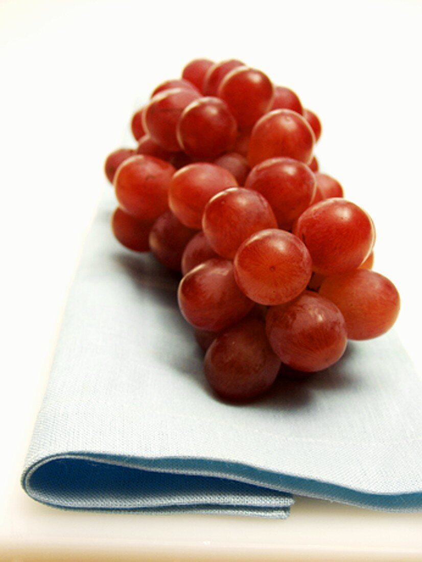 Bunch of Red Grapes Resting on a Blue Cloth
