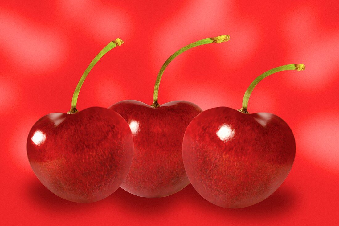 Three cherries against red background