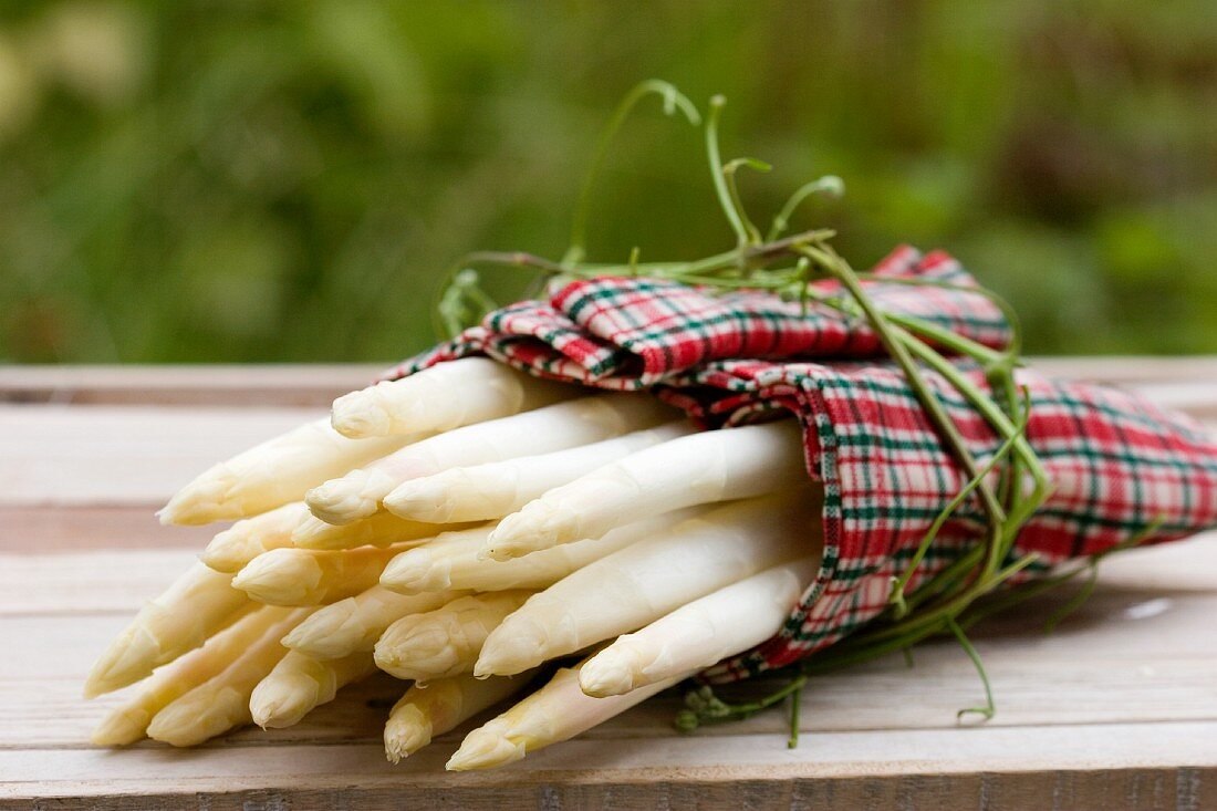 Weisser Spargel im Tuch mit Clematisranke