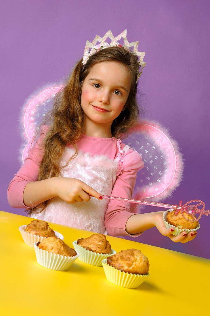 Girl dressed as fairy with muffins