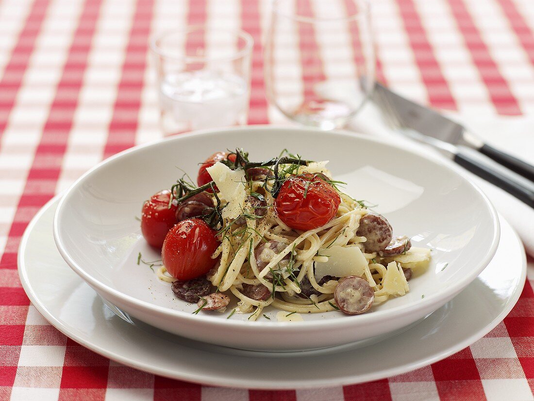 Spaghetti mit Wurstscheiben und Cocktailtomaten