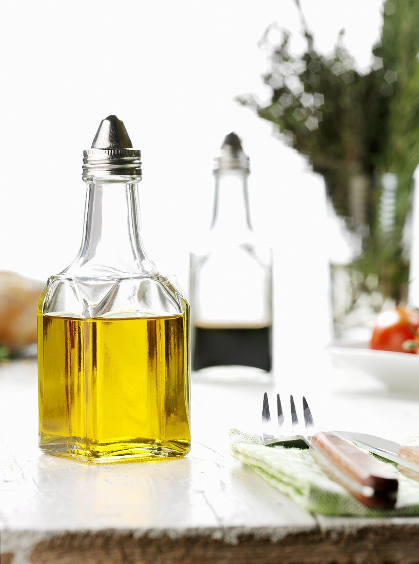 Olivenöl, Besteck und im Hintergrund Balsamicoessig