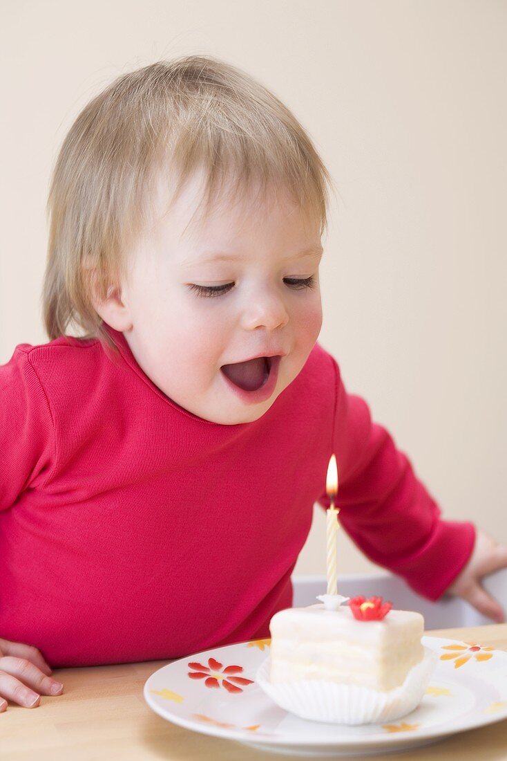 Small girl blowing out a birthday candle